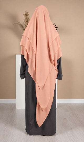 Roze chiffon khimar met lange, asymmetrische stroken en verborgen zwarte onderlaag