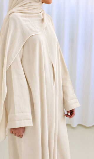 Linnen abaya crèmekleur met drapeerplooien, losvallende rok en lange mouw