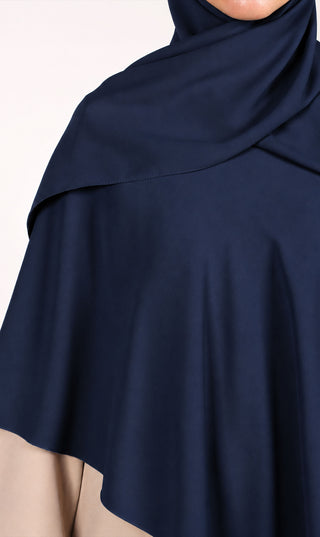 Donkerblauwe khimar-sjaal met capuchon en plooival; close-up van stof en zoom.