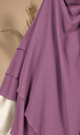 Paarse chiffon khimar met draperende lagen en brede zoom, mouwloos ontwerp.