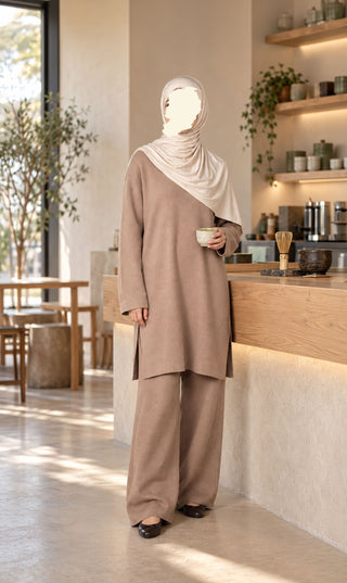 Gebreide set in taupe met lange tuniek en wijde broek, met witte hoofddoek en beker.