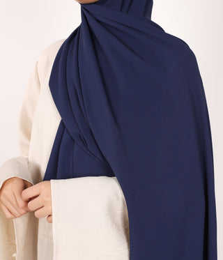 Marineblauwe chiffon sjaal met duidelijke plooien, over schouder en hals