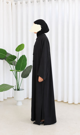 Nakaizu co-ord set, zwarte lange jurk zijaanzicht met capuchon en knoopsluiting