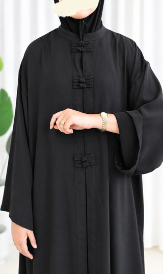 Zwarte co-ord set: lange kaftan met opstaande hals, knoopdetail en wijde mouwen.