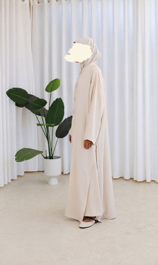 Nakaizu co-ord set, crèmekleurige lange jurk in zijaanzicht met knoopdetail