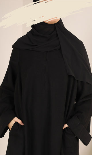 Zwarte abaya met hoge opstaande kraag en afgeronde, wijde schouderdrape
