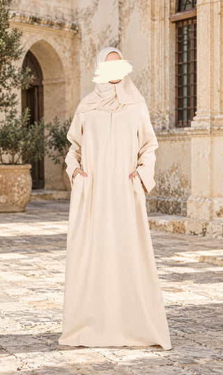 Lange crèmekleurige abaya met drapering bij de hals en uitwaaierende zoom