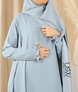 Blauwgrijze khimar met plooival bij de taille en hoge halsboord, close-up op de handen